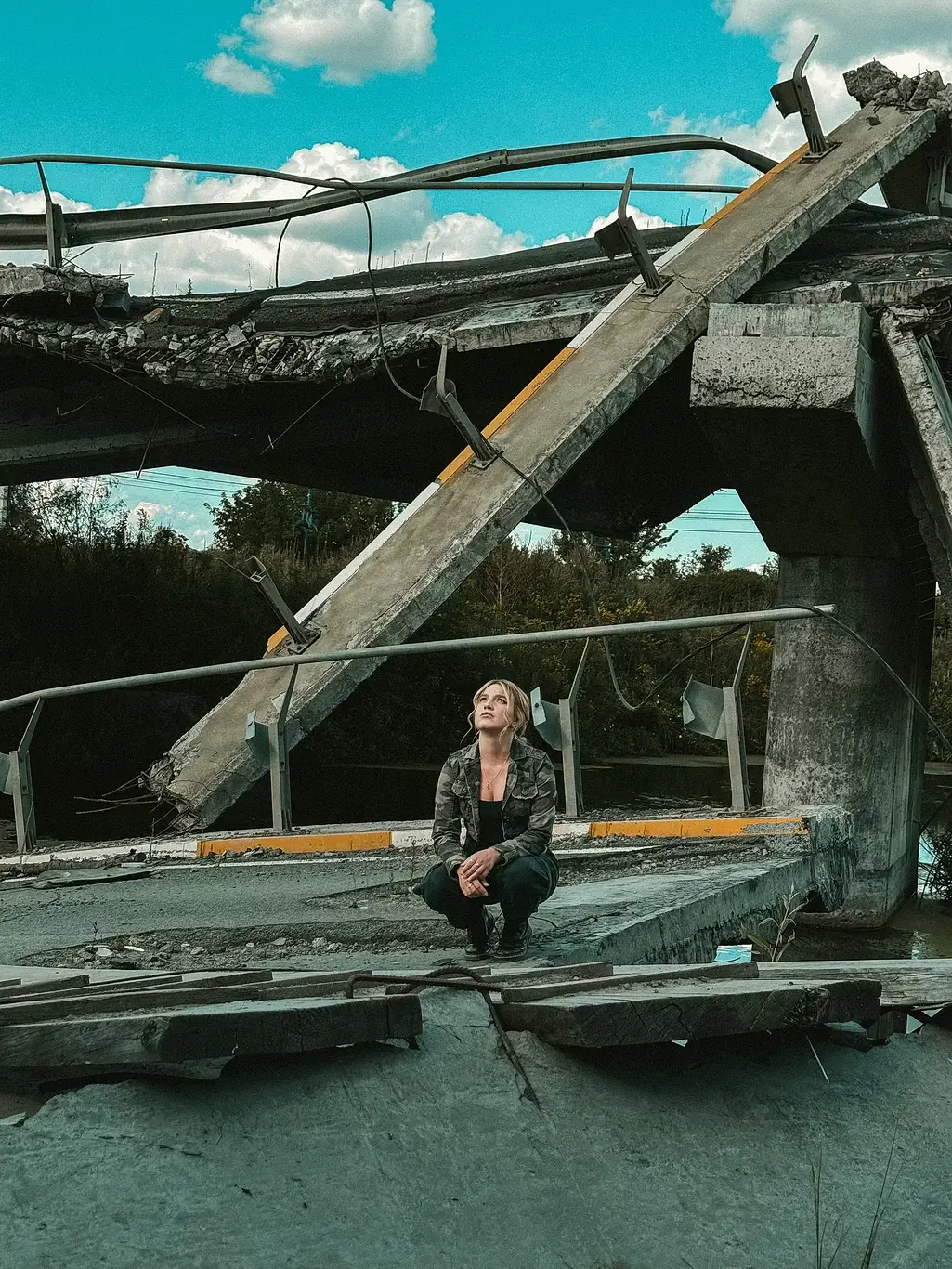Kelsey Kimberlin sits near a destroyed bridge Kelsey Kimberlin sits near a destroyed bridge