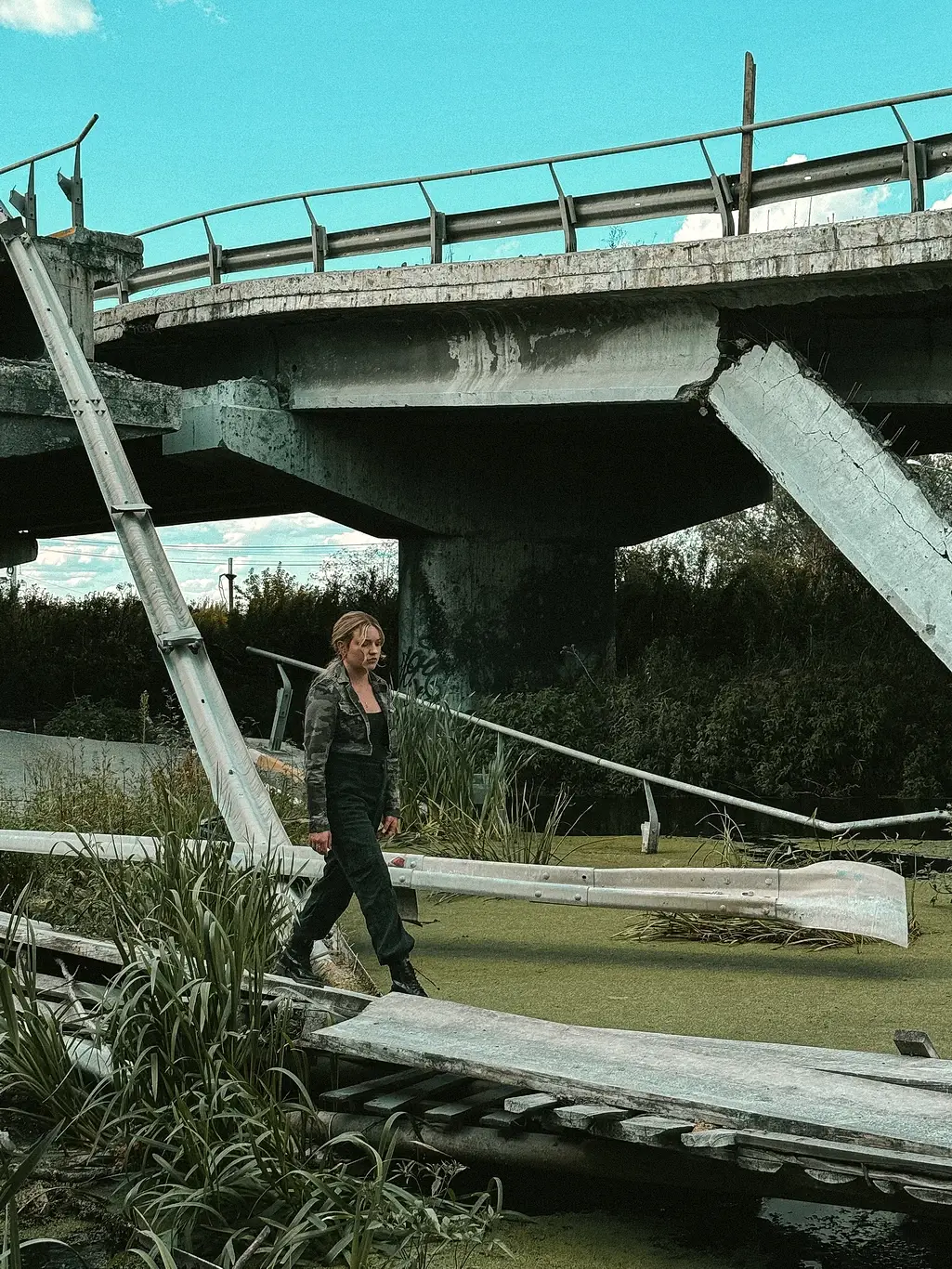 Kelsey Kimberlin walks near a destroyed bridge Kelsey Kimberlin walks near a destroyed bridge