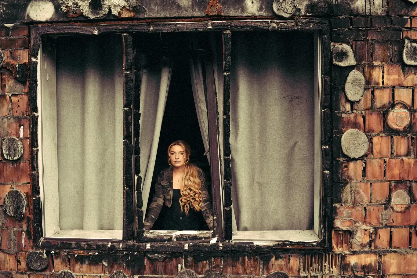 Kelsie Kimberlin looks out the window of a destroyed home