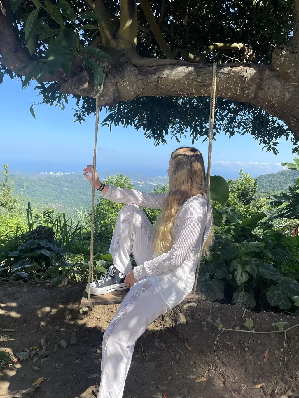 Kelsie Kimberlin sits on a swing and looks at the mountains