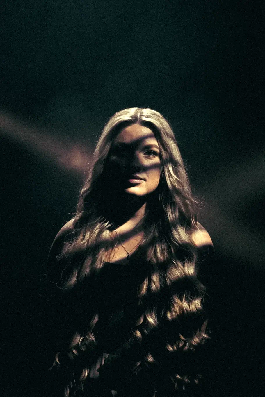 Kelsie Kimberlin stands in a dark room