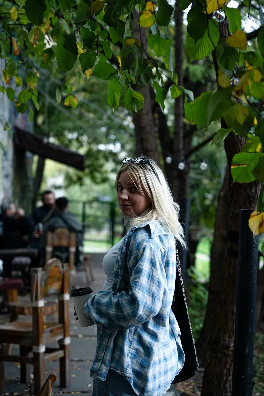 Kelsie Kimberlin stands outside and drinks coffee