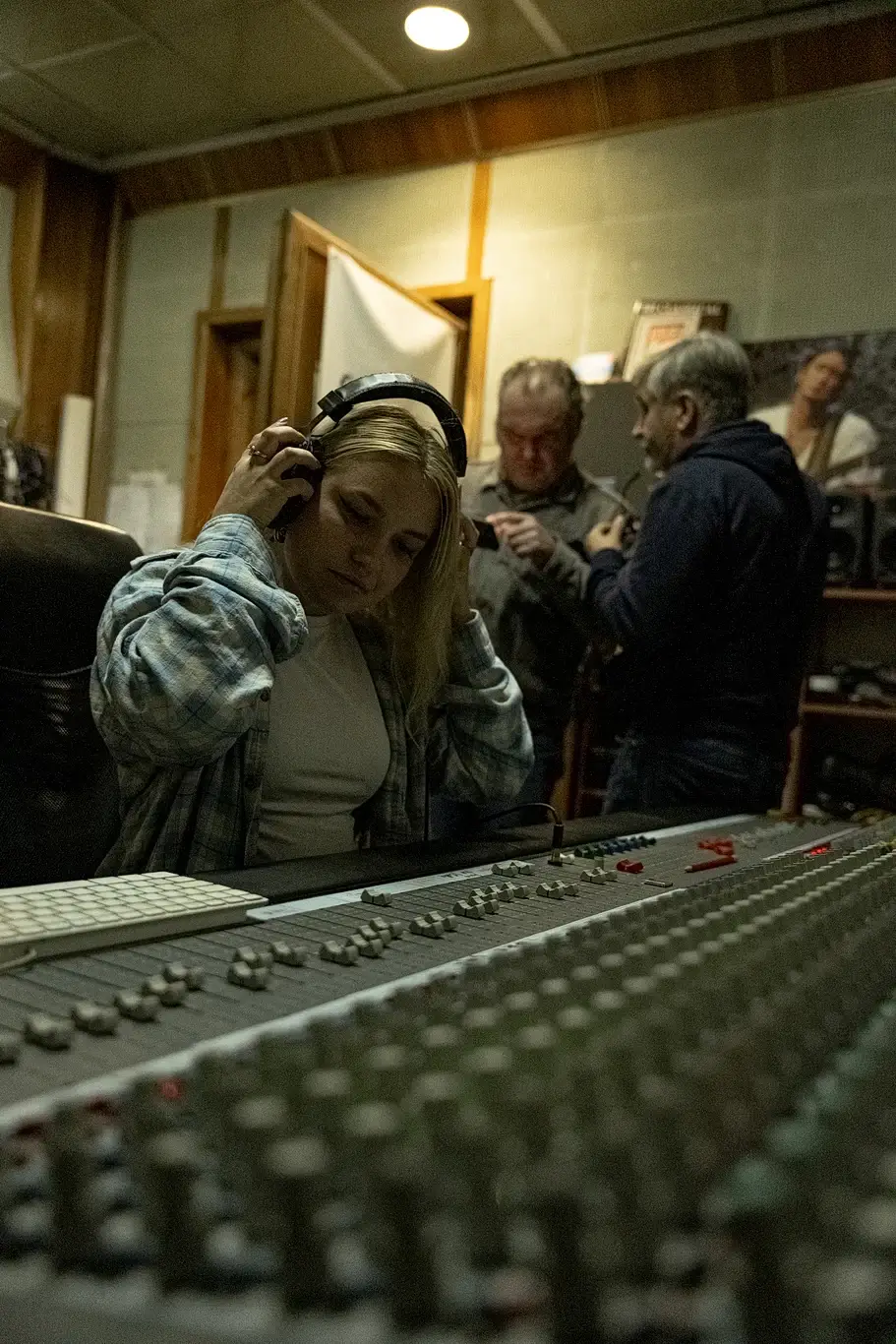 Kelsie Kimberlin is sitting with headphones and listening recording